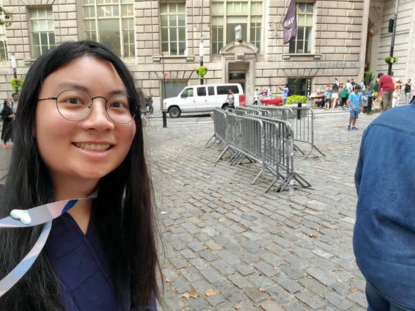 Esthie Standard Duong in a Buddhist monk robe purchased from Amazon for $50, in front of the old Standard Oil building, 2023